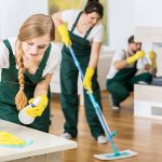 Group of friends as a professional cleaners tiding up big apartment